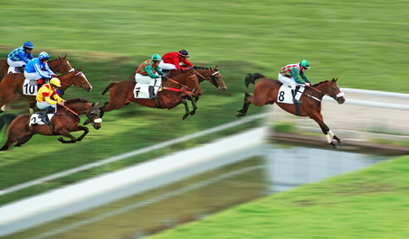 Chevaux qui sautent un obstacle de type rivière dans une course de galop